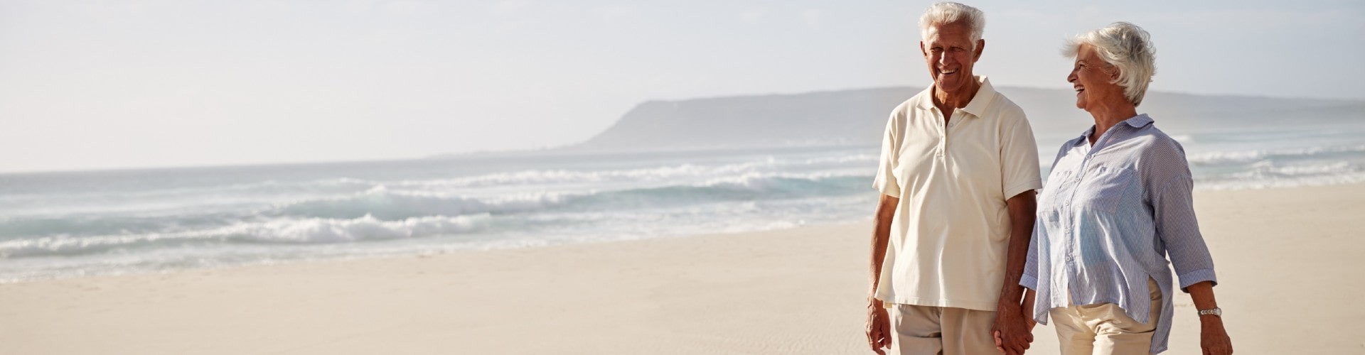 senior couple walking at the beach